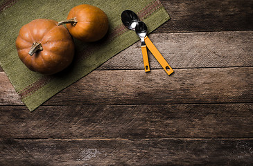 Image showing Two pumpkins with spoons on green napkin and wood in Rustic styl