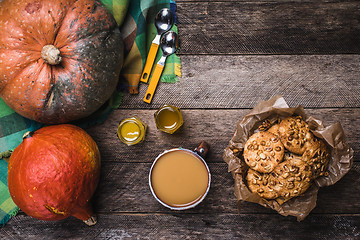 Image showing Rustic style pumpkins, soup, honey and cookies with nuts on wood