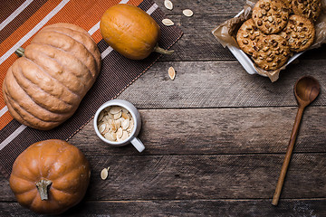 Image showing Rustic style pumpkins, seeds and cookies with nuts on wooden tab
