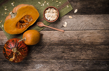 Image showing Rustic style pumpkins with seeds on green napkin and wood 