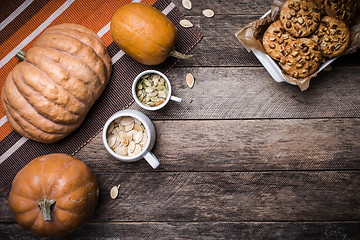 Image showing Rustic style pumpkins, seeds and cookies with nuts on table