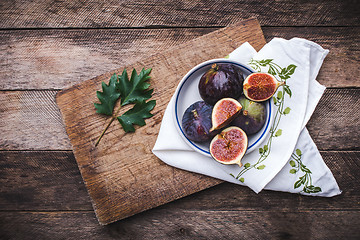 Image showing Figs in flat dish on choppingboard and napkin in rustic style