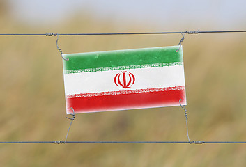 Image showing Border fence - Old plastic sign with a flag