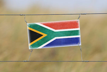 Image showing Border fence - Old plastic sign with a flag