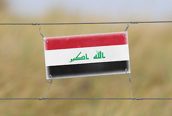 Image showing Border fence - Old plastic sign with a flag