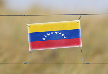 Image showing Border fence - Old plastic sign with a flag