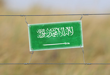 Image showing Border fence - Old plastic sign with a flag