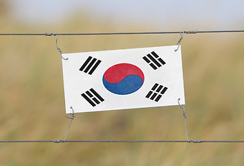 Image showing Border fence - Old plastic sign with a flag