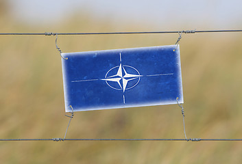 Image showing Border fence - Old plastic sign with a flag