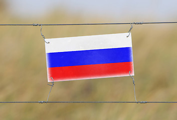 Image showing Border fence - Old plastic sign with a flag