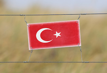 Image showing Border fence - Old plastic sign with a flag