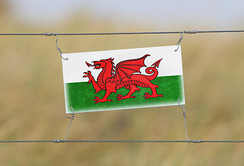 Image showing Border fence - Old plastic sign with a flag