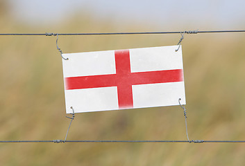 Image showing Border fence - Old plastic sign with a flag