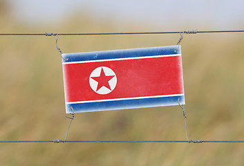 Image showing Border fence - Old plastic sign with a flag