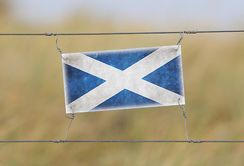 Image showing Border fence - Old plastic sign with a flag