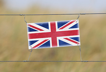 Image showing Border fence - Old plastic sign with a flag