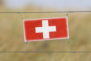 Image showing Border fence - Old plastic sign with a flag