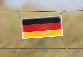 Image showing Border fence - Old plastic sign with a flag