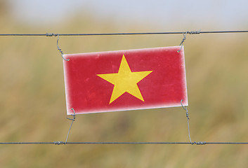 Image showing Border fence - Old plastic sign with a flag