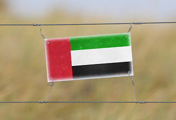 Image showing Border fence - Old plastic sign with a flag