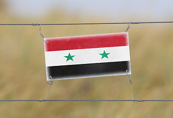 Image showing Border fence - Old plastic sign with a flag