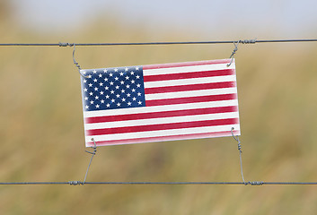 Image showing Border fence - Old plastic sign with a flag