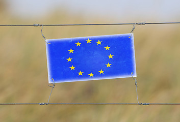 Image showing Border fence - Old plastic sign with a flag