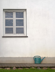 Image showing plastic watering can near the white wall