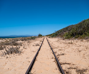 Image showing Steel Railroad Tracks on Sand Beach