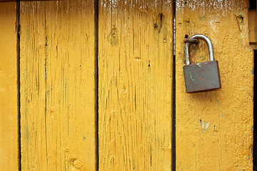 Image showing padlock on yellow wooden door