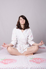 Image showing Woman meditating sitting on the bed