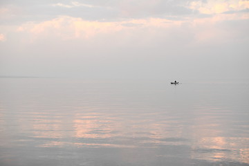 Image showing silhouette of a fishing boat on the horizon