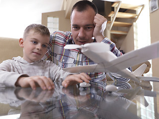 Image showing father and son assembling airplane toy