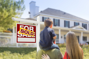 Image showing Family Facing Sold For Sale Real Estate Sign and House