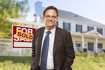 Image showing Real Estate Agent in Front of Sold Sign and House