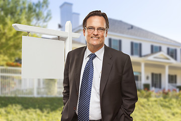Image showing Male Real Estate Agent in Front of Blank Sign and House