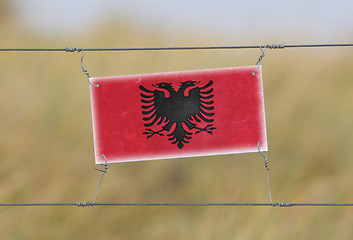 Image showing Border fence - Old plastic sign with a flag