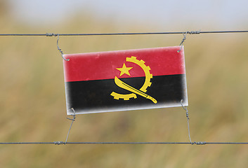 Image showing Border fence - Old plastic sign with a flag