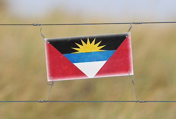 Image showing Border fence - Old plastic sign with a flag