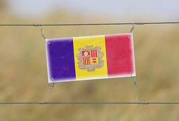 Image showing Border fence - Old plastic sign with a flag