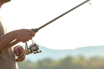 Image showing Modern clean fishing rod in hands