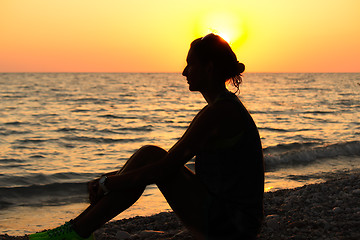 Image showing The silhouette of the girl on the beach in the sun.