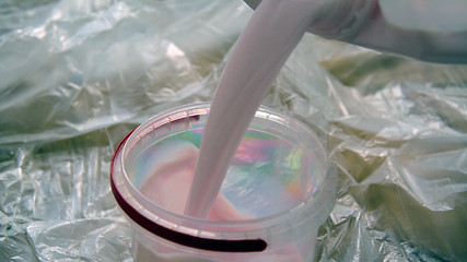 Image showing Pouring prime coat into the plastic bin