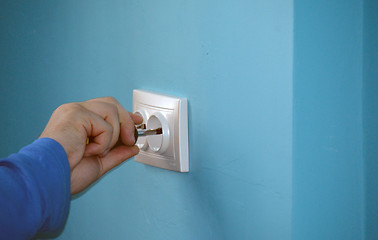 Image showing electrician fixing a socket cover on the wall