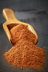 Image showing Wooden scoop with ground cinnamon