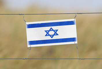 Image showing Border fence - Old plastic sign with a flag