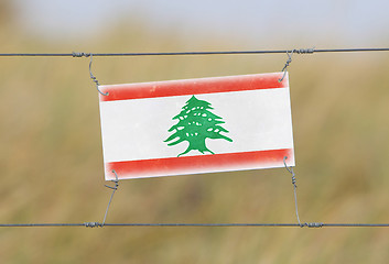 Image showing Border fence - Old plastic sign with a flag