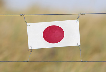 Image showing Border fence - Old plastic sign with a flag