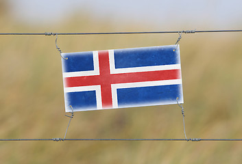 Image showing Border fence - Old plastic sign with a flag