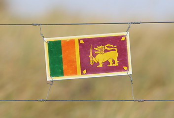 Image showing Border fence - Old plastic sign with a flag